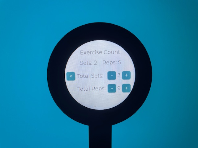 The exercise count screen photographed with the round back device. It has a header which reads 'Track Exercise' and then lists 'Crunches', 'Bicep Curl', and 'Jump Rope'. Each is next to a button which reads 'Track'.